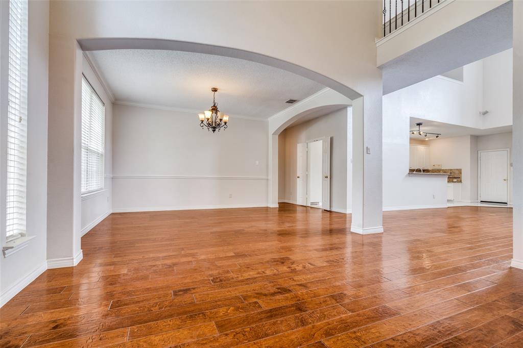 3421 Neiman Road Plano, TX 75025 - Photo 6 of 40 Unfurnished living room with a chandelier, wood finished floors, and arched walkways