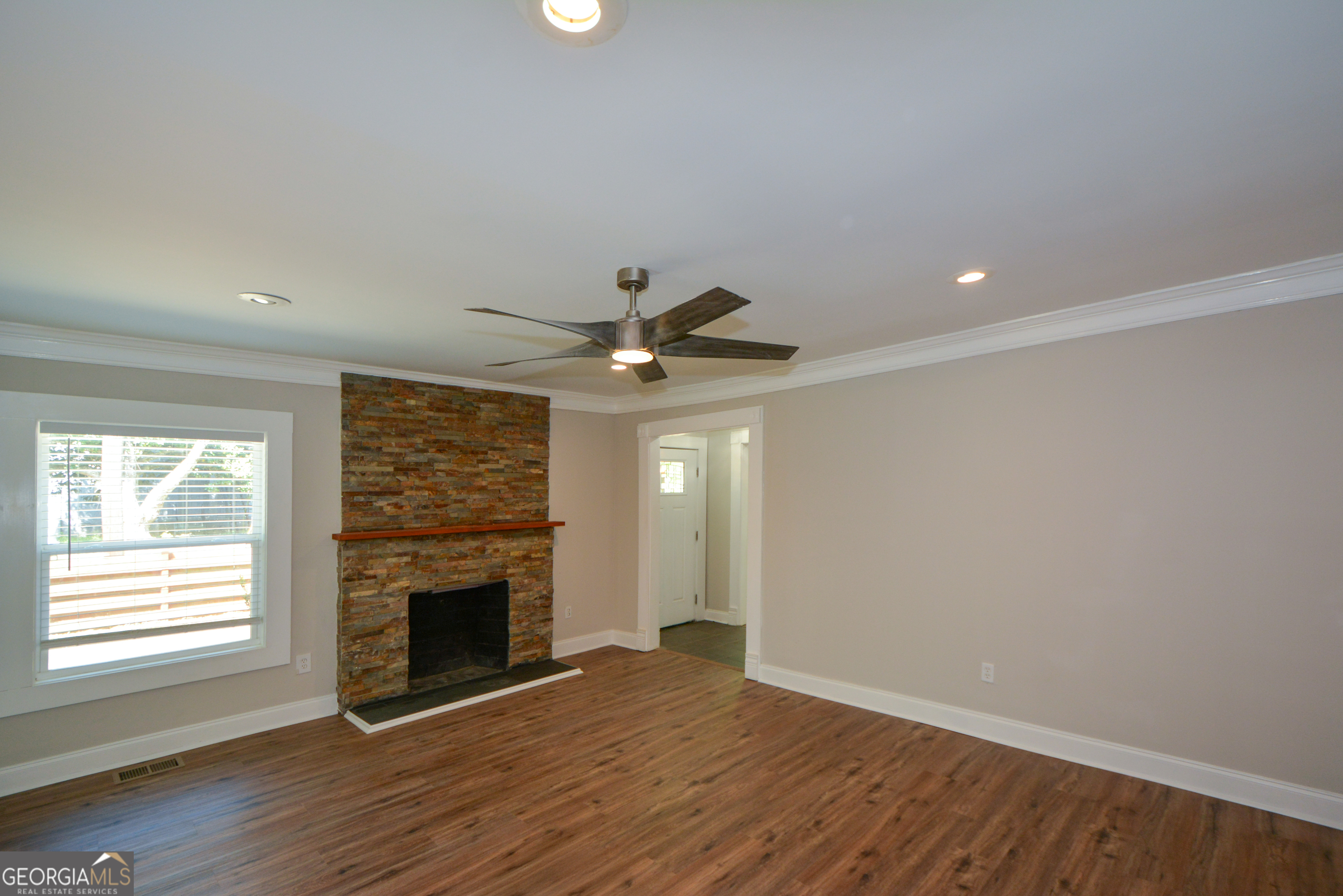 3164 Harris Drive East Point, GA 30344 - Photo 10 of 40 an empty room with windows a fireplace and wooden floor