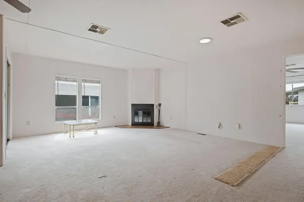 an empty room with windows and fireplace