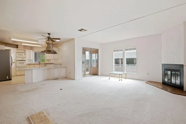 a view of an empty room with a fireplace and a window