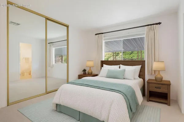 a bedroom with a bed and a large mirror