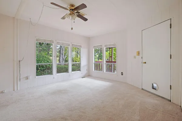 a view of a livingroom with a ceiling fan and window