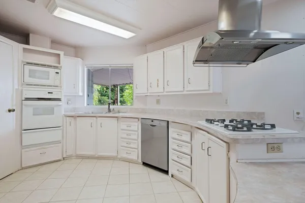 a kitchen with white cabinets and appliances