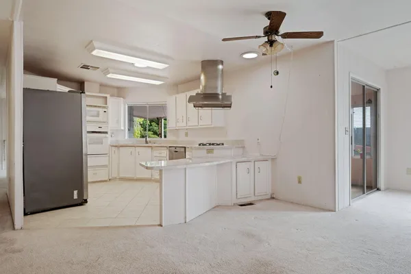 a kitchen with white cabinets and refrigerator