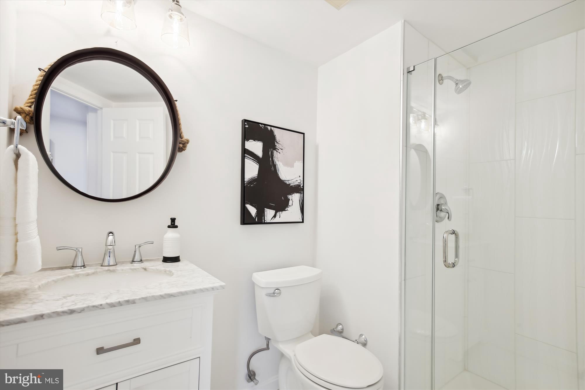 2400 Clarendon Boulevard, Unit 414 Arlington, VA 22201 - Photo 21 of 39 a bathroom with a granite countertop toilet a sink and a mirror