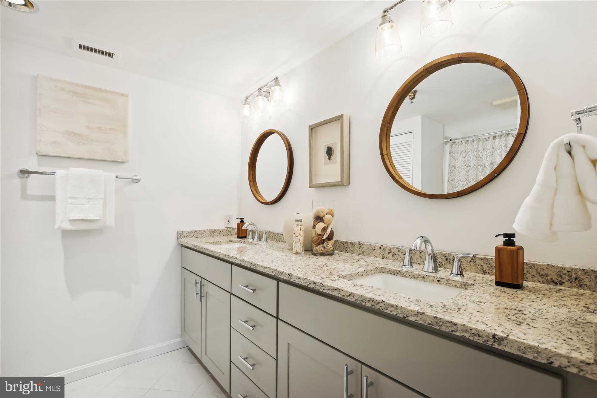2400 Clarendon Boulevard, Unit 414 Arlington, VA 22201 - Photo 23 of 39 a bathroom with a granite countertop double vanity sink and a mirror