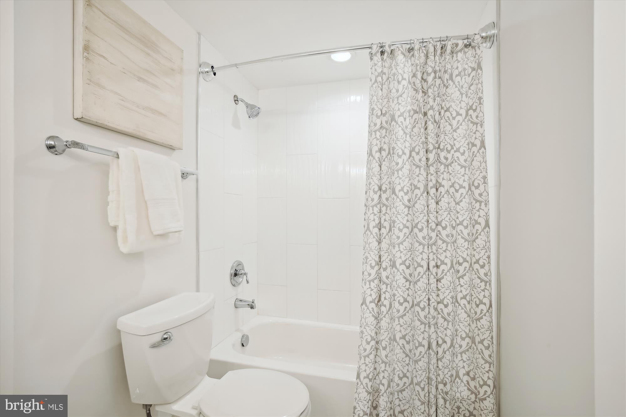 2400 Clarendon Boulevard, Unit 414 Arlington, VA 22201 - Photo 24 of 39 a bathroom with a shower curtain and a toilet