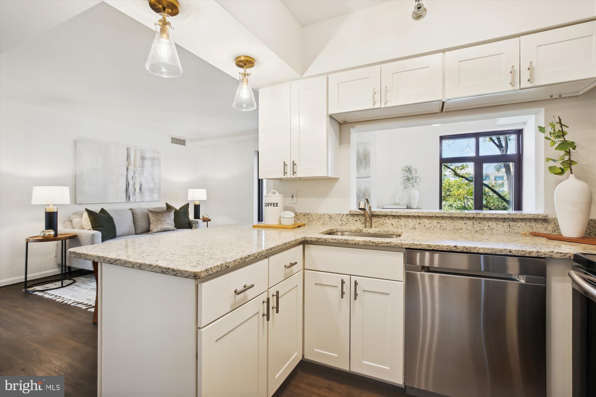 2400 Clarendon Boulevard, Unit 414 Arlington, VA 22201 - Photo 8 of 39 a kitchen with a sink dishwasher and white cabinets with wooden floor