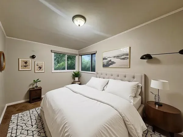 a bedroom with a bed and a lamp on dresser