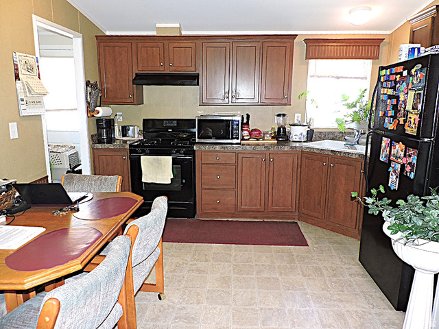 915 North 5000 W Road Hinckley, UT 84635 - Photo 8 of 27 Kitchen featuring wood-finish cabinetry, dark countertops, range with overhead ventilation, and a window with a valance