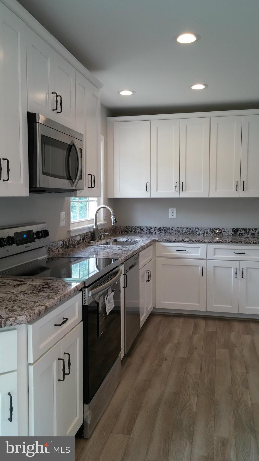 24411 Morgan Road Hollywood, MD 20636 - Photo 5 of 28 a kitchen with granite countertop white cabinets and stainless steel appliances