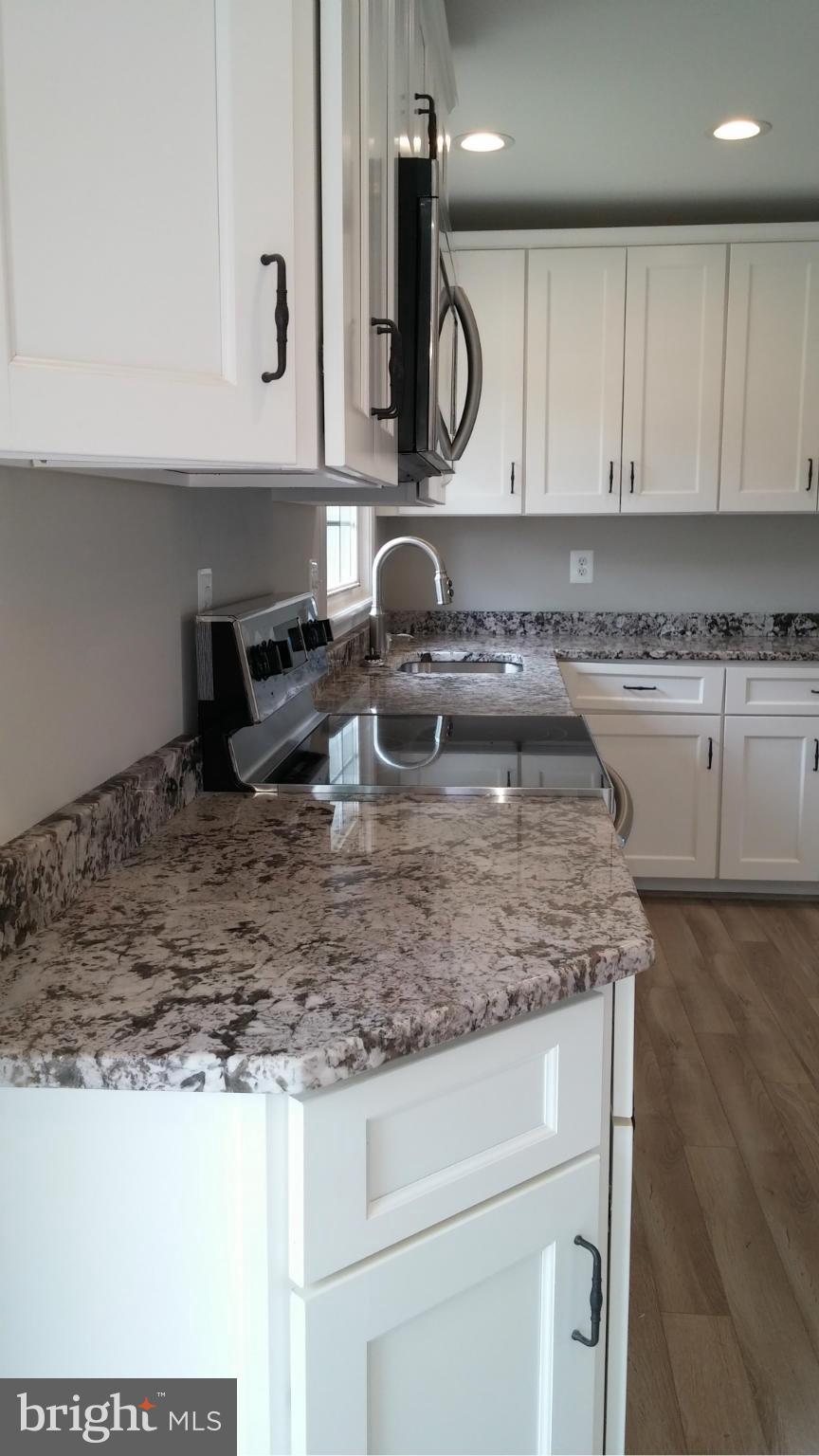 24411 Morgan Road Hollywood, MD 20636 - Photo 6 of 28 a kitchen with kitchen island granite countertop a sink and a stove