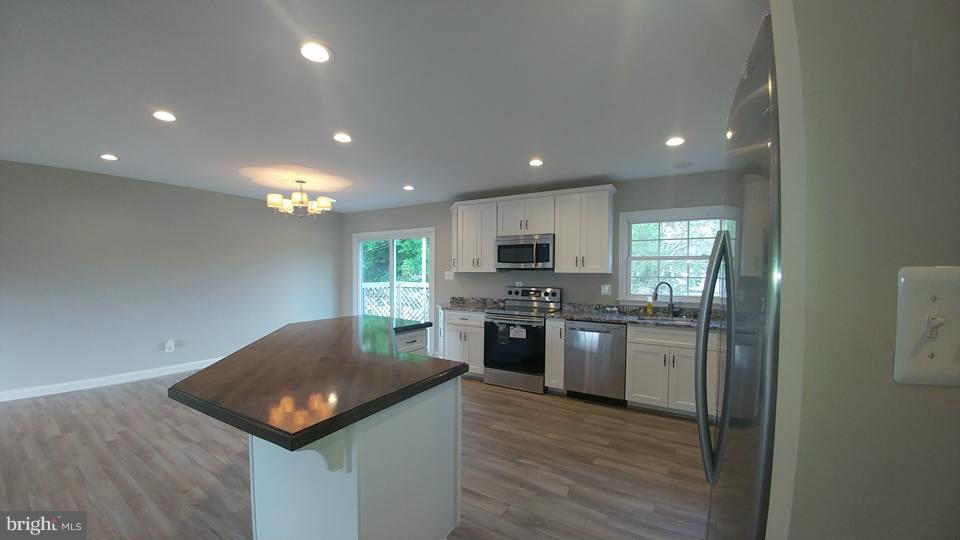24411 Morgan Road Hollywood, MD 20636 - Photo 8 of 28 a kitchen with stainless steel appliances granite countertop a sink a stove top oven a counter space and cabinets