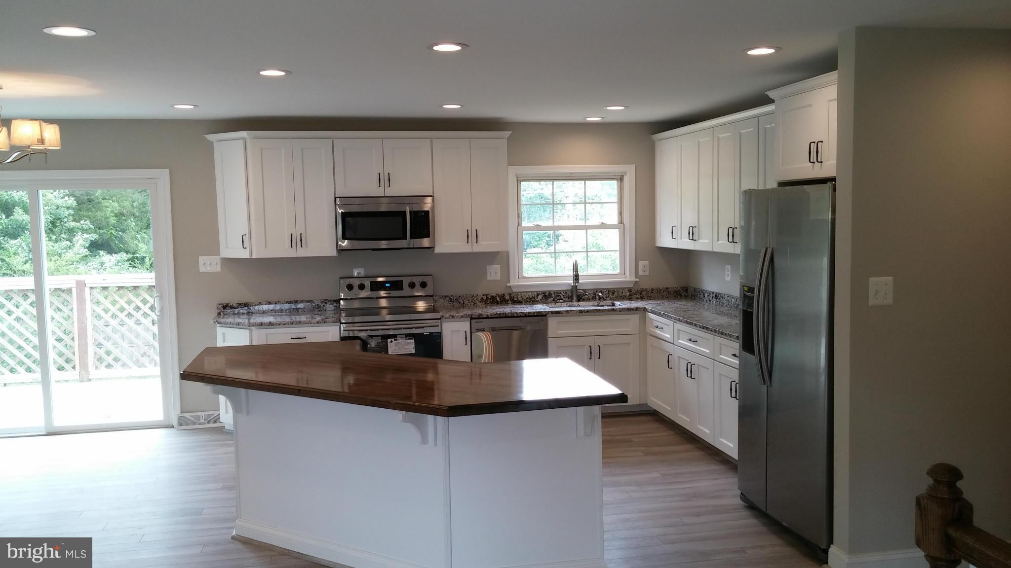 24411 Morgan Road Hollywood, MD 20636 - Photo 9 of 28 a kitchen with stainless steel appliances granite countertop a stove a sink and a refrigerator