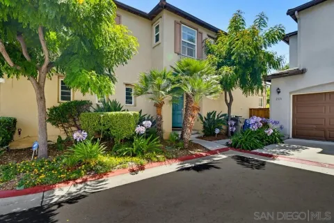 a front view of a house with a garden and tree