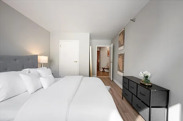 a bedroom with a bed and a lamp on the dresser