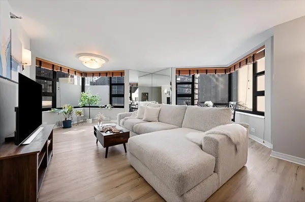 a living room with furniture a flat screen tv and a large window