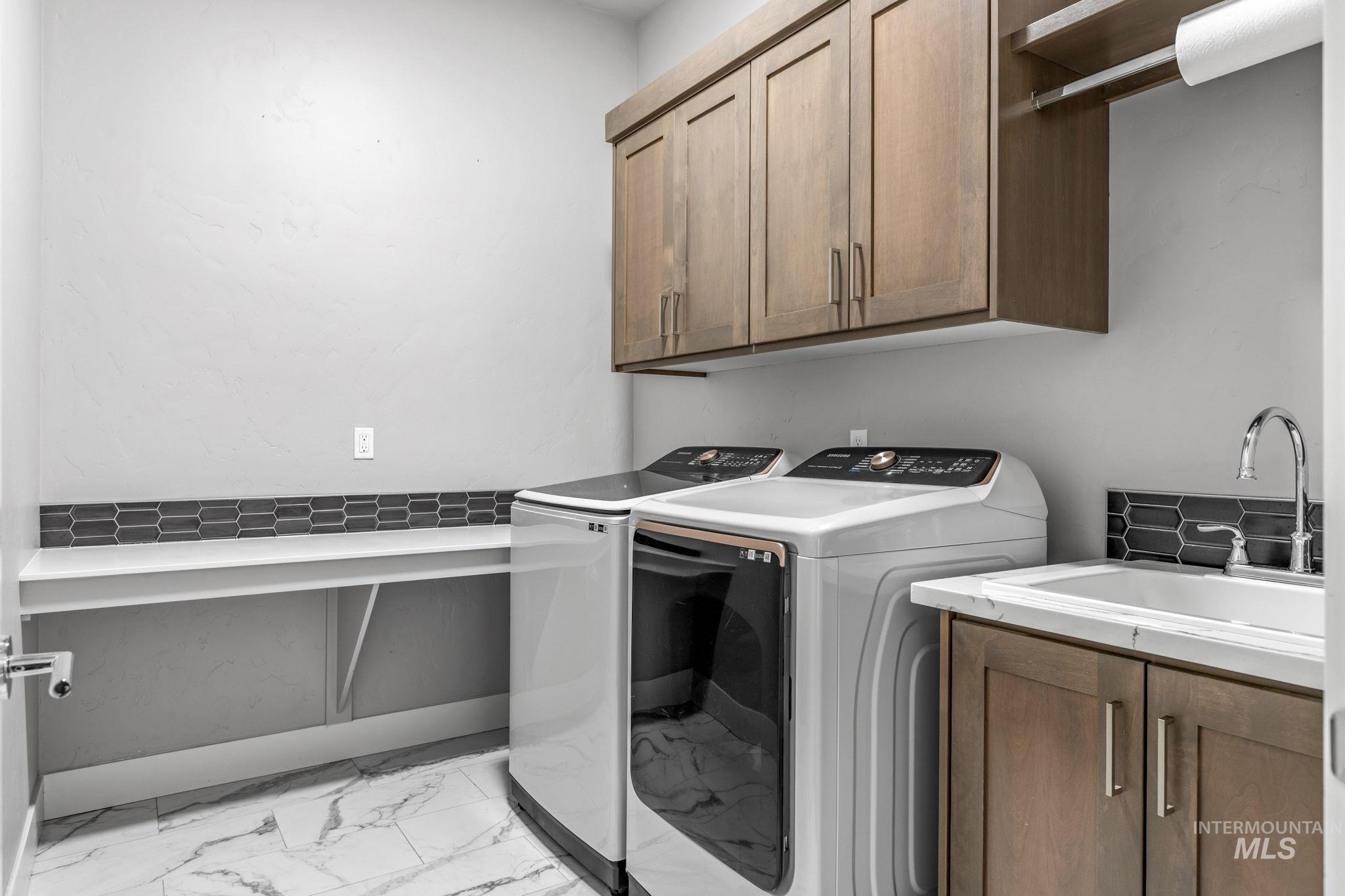 2934 East Murchison Street Meridian, ID 83642 - Photo 20 of 44 Dedicated laundry area featuring wood-finish cabinetry, a utility sink, and a built-in folding counter