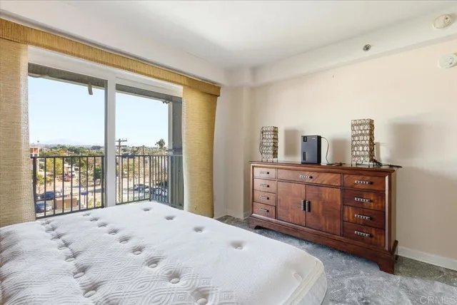 a bedroom with a bed dresser and a large window