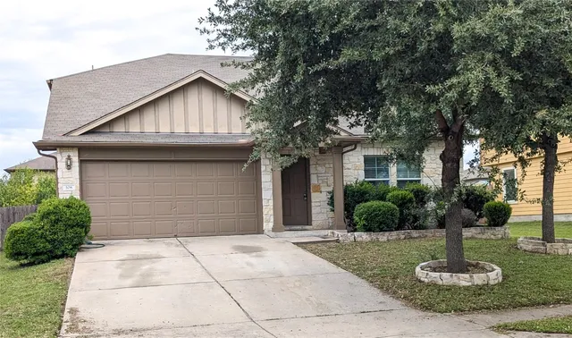 a front view of a house with a yard garage and outdoor seating