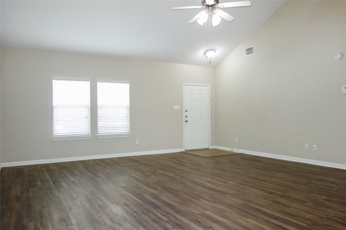 108 Lavaca Loop Hutto, TX 78634 - Photo 4 of 39 an empty room with wooden floor chandelier fan and windows