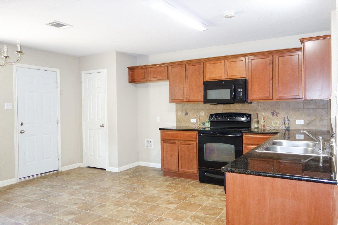 108 Lavaca Loop Hutto, TX 78634 - Photo 8 of 39 a kitchen with stainless steel appliances granite countertop a stove a sink and a refrigerator