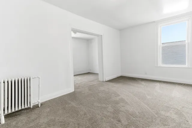an empty room with a fireplace and windows