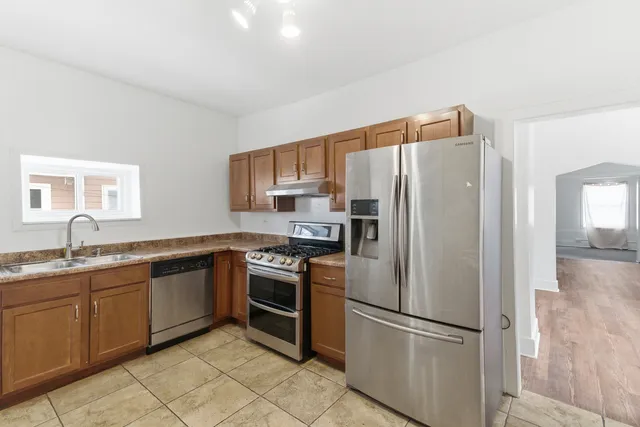 a kitchen with stainless steel appliances granite countertop a refrigerator sink and stove