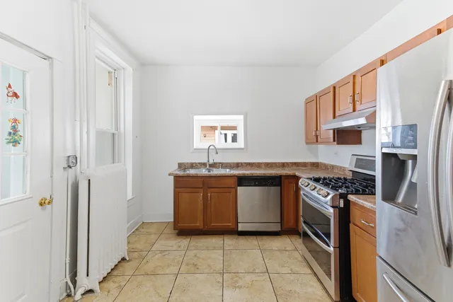 a kitchen with stainless steel appliances granite countertop a stove a sink and a refrigerator