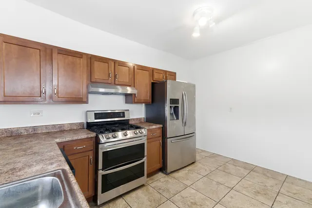 a kitchen with granite countertop a stove and a refrigerator