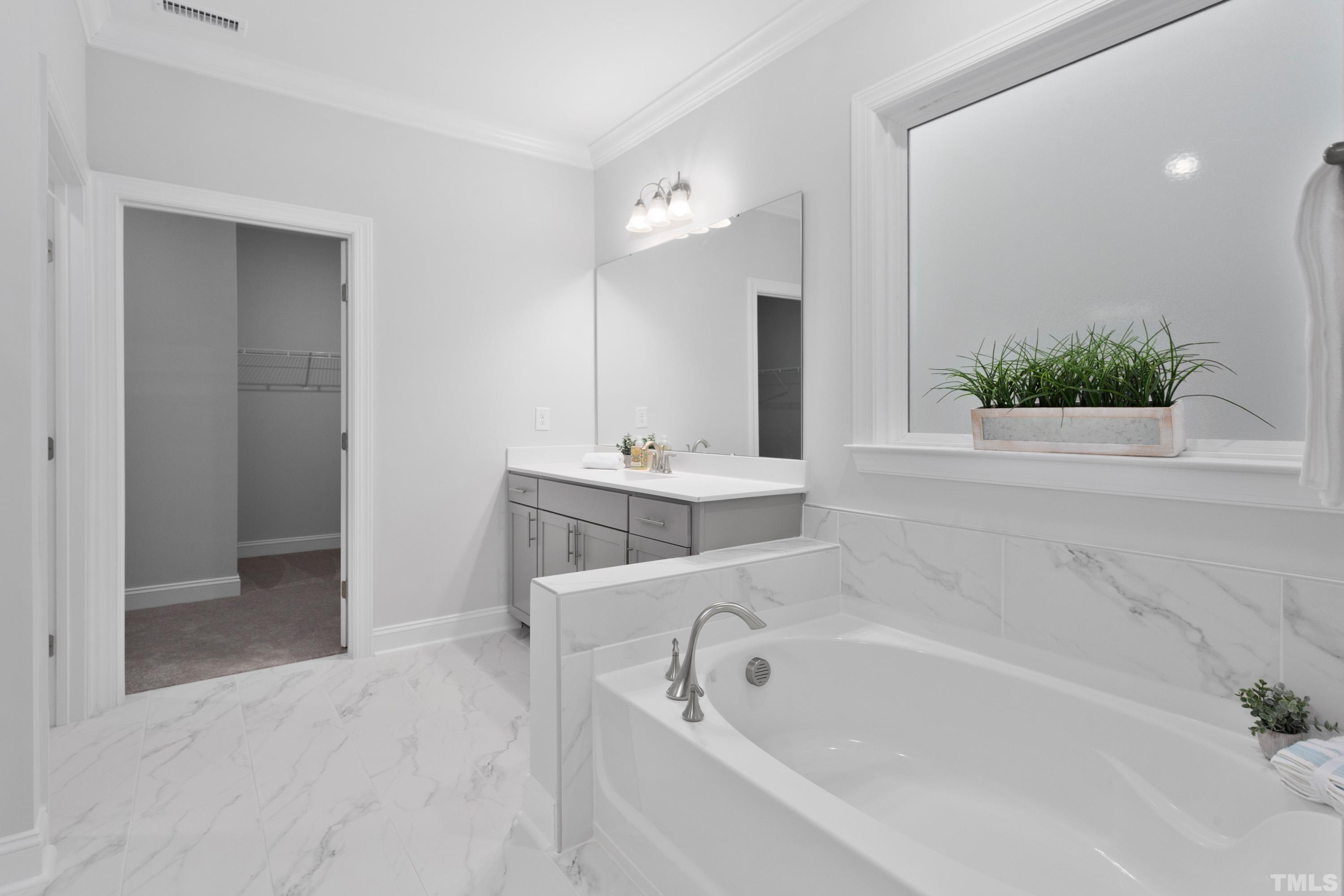 137 English Violet Lane Raleigh, NC 27610 - Photo 10 of 27 a white bath tub sitting in a bathroom and mirror