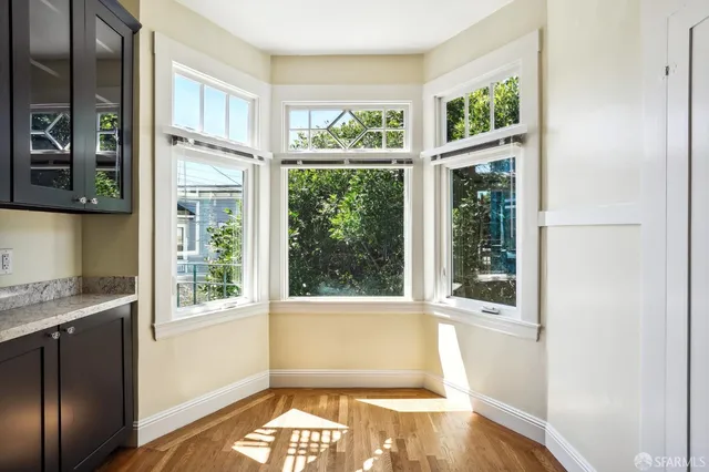 a view of empty room with windows and wooden floor