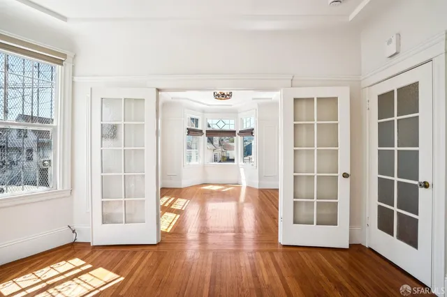 an empty room with wooden floor and mirror