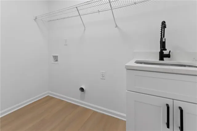 an empty room with wooden floor chandelier fan and windows
