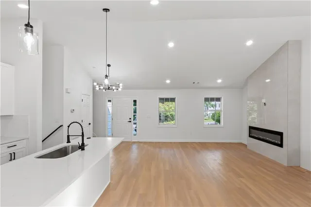 a kitchen with a sink chandelier and wooden floor