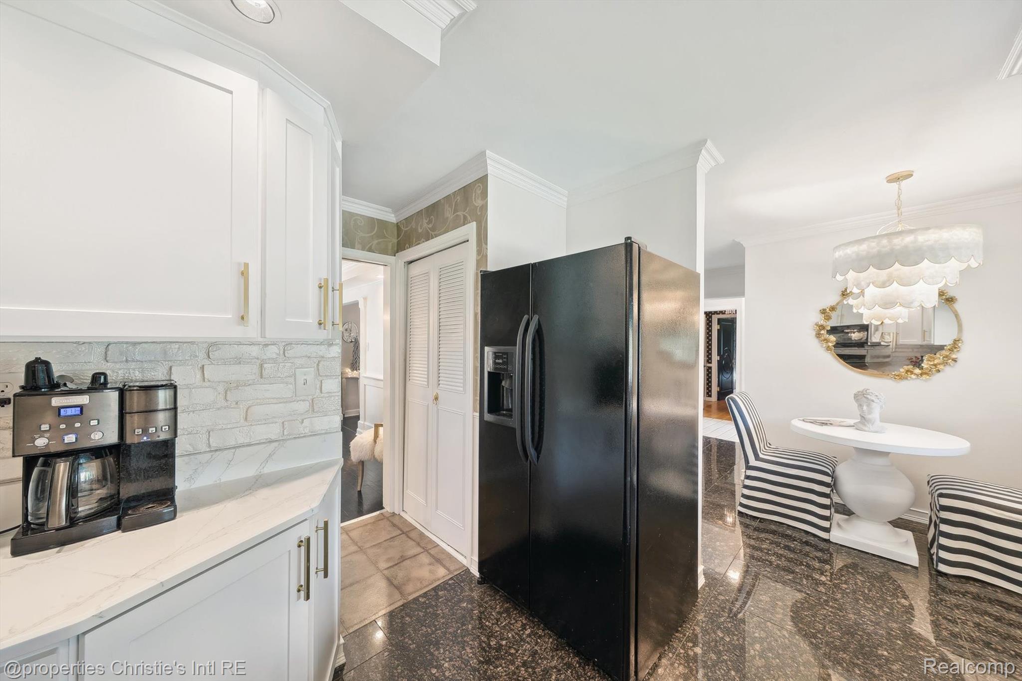 511 South Gulley Road Dearborn, MI 48124 - Photo 20 of 43 White cabinetry with gold-tone hardware, stacked stone backsplash, white countertop, black side-by-side refrigerator, and dark-finish flooring