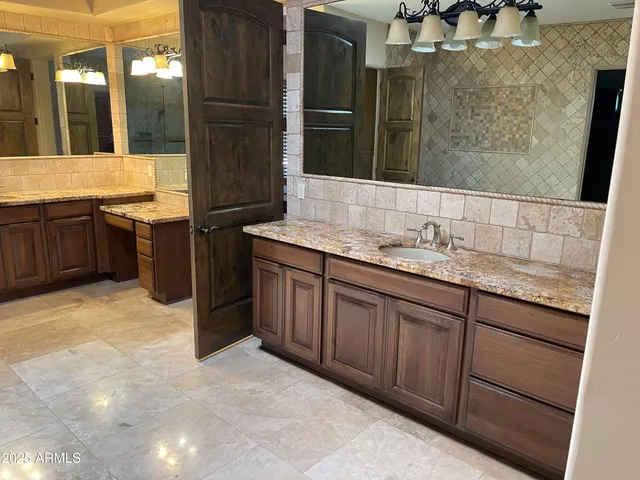 a bathroom with a granite countertop sink and a mirror