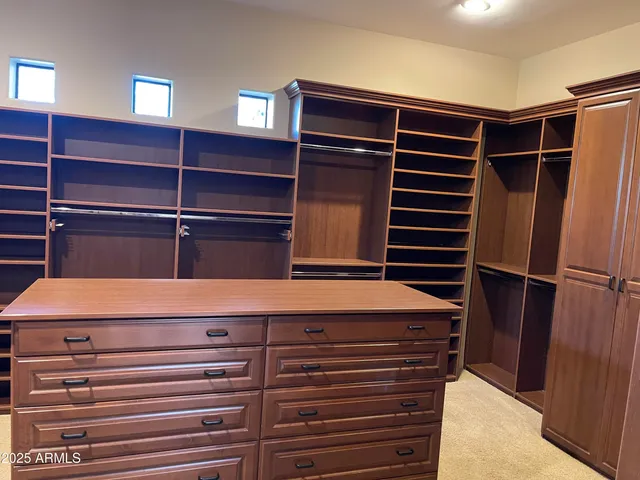 a view of walk in closet with empty racks