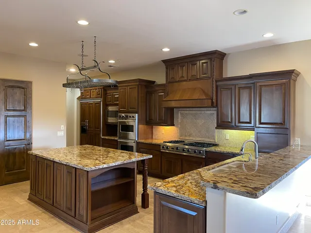 a kitchen with stainless steel appliances granite countertop a stove and a refrigerator