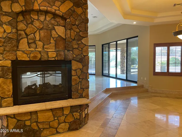 a view of an empty room with wooden floor and a fireplace