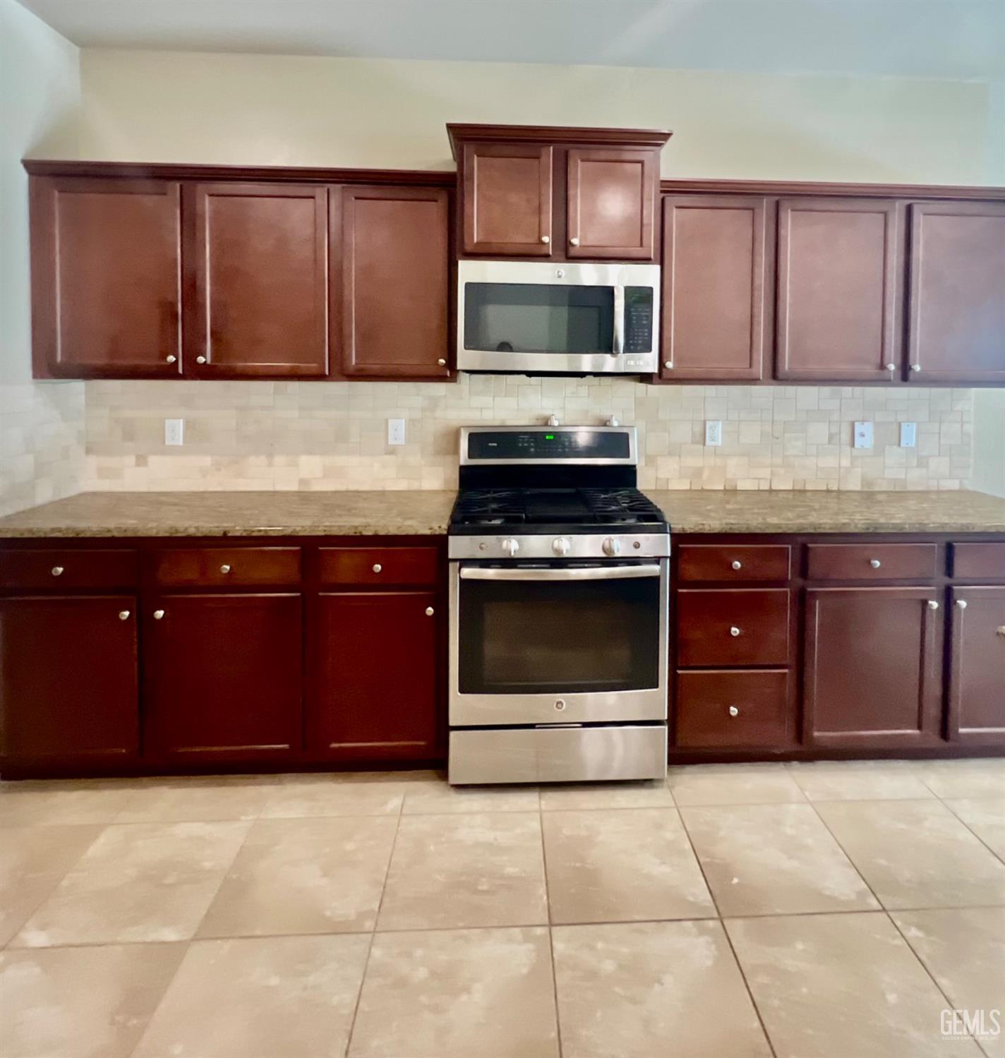 Undisclosed Address Bakersfield, CA 93311 - Photo 16 of 63 a kitchen with a stove and a microwave