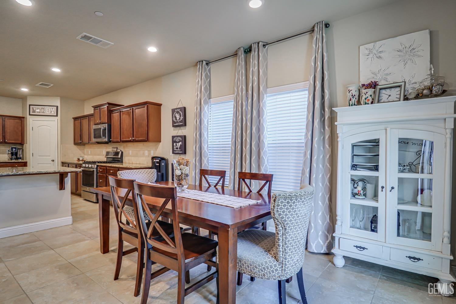 Undisclosed Address Bakersfield, CA 93311 - Photo 20 of 63 a kitchen with a dining table chairs and refrigerator