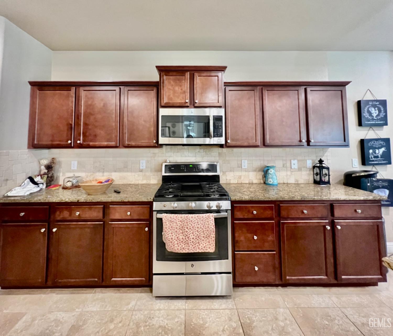 Undisclosed Address Bakersfield, CA 93311 - Photo 29 of 63 a kitchen with stainless steel appliances granite countertop a stove a sink and a microwave