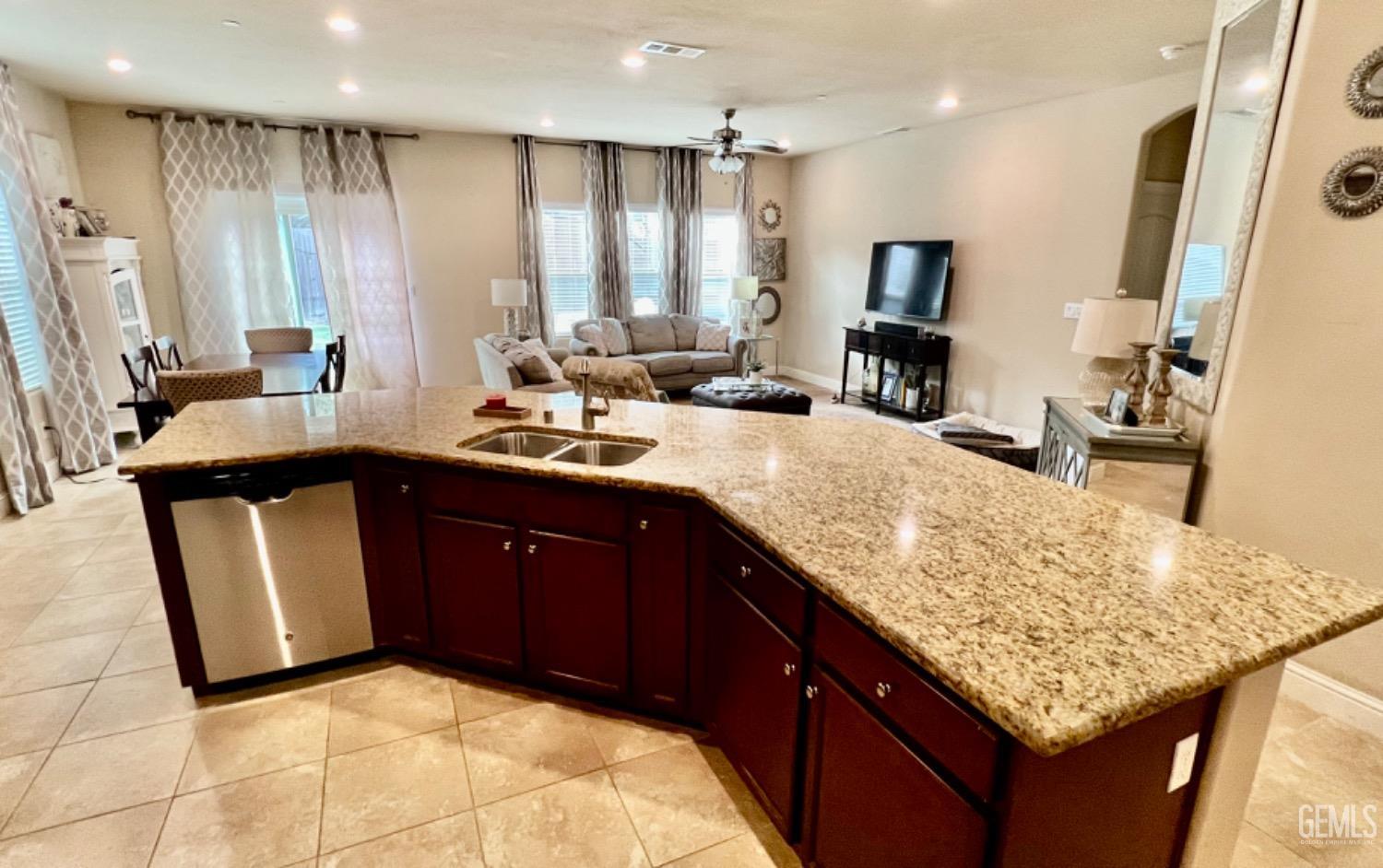 Undisclosed Address Bakersfield, CA 93311 - Photo 31 of 63 a kitchen with kitchen island granite countertop a sink counter top space and living room view
