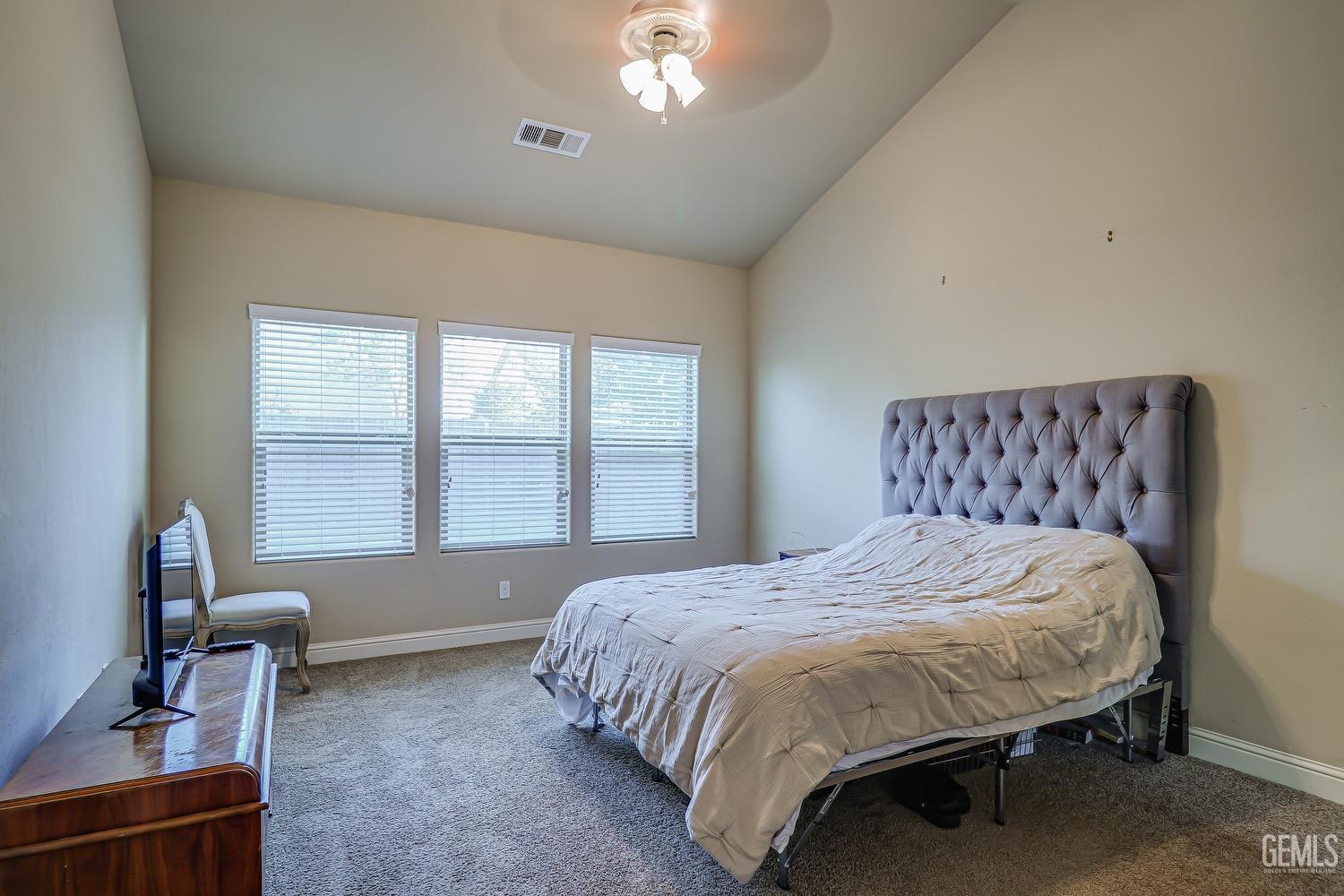 Undisclosed Address Bakersfield, CA 93311 - Photo 39 of 63 a bedroom with a bed next to a window and a chair