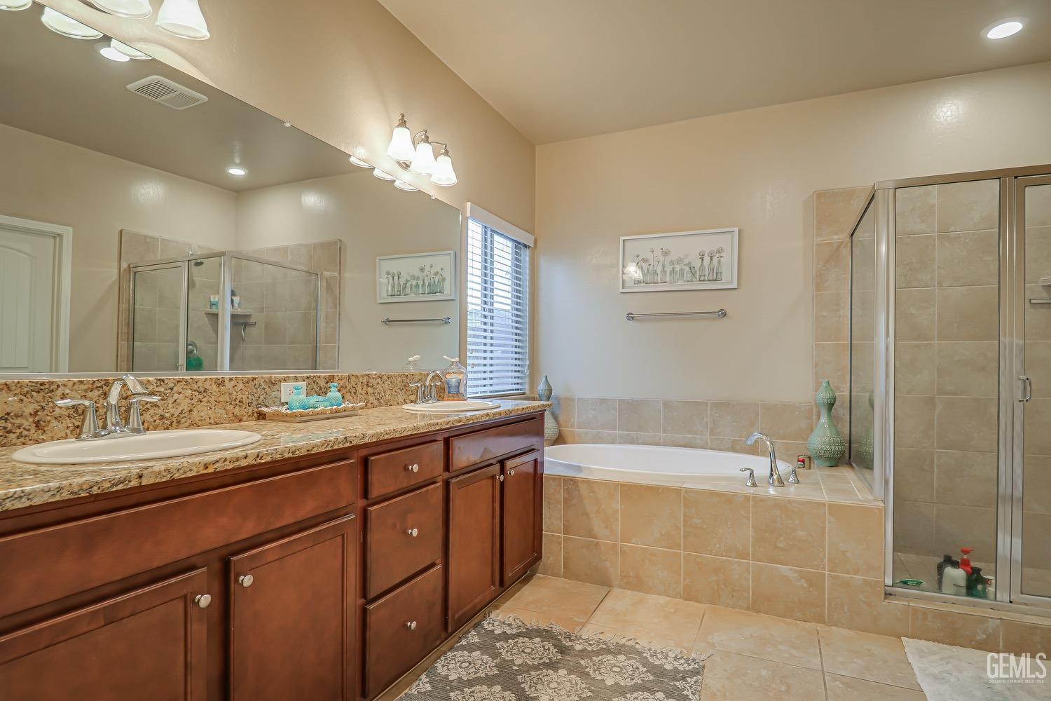 Undisclosed Address Bakersfield, CA 93311 - Photo 47 of 63 a bathroom with a granite countertop sink a large mirror and a bathtub