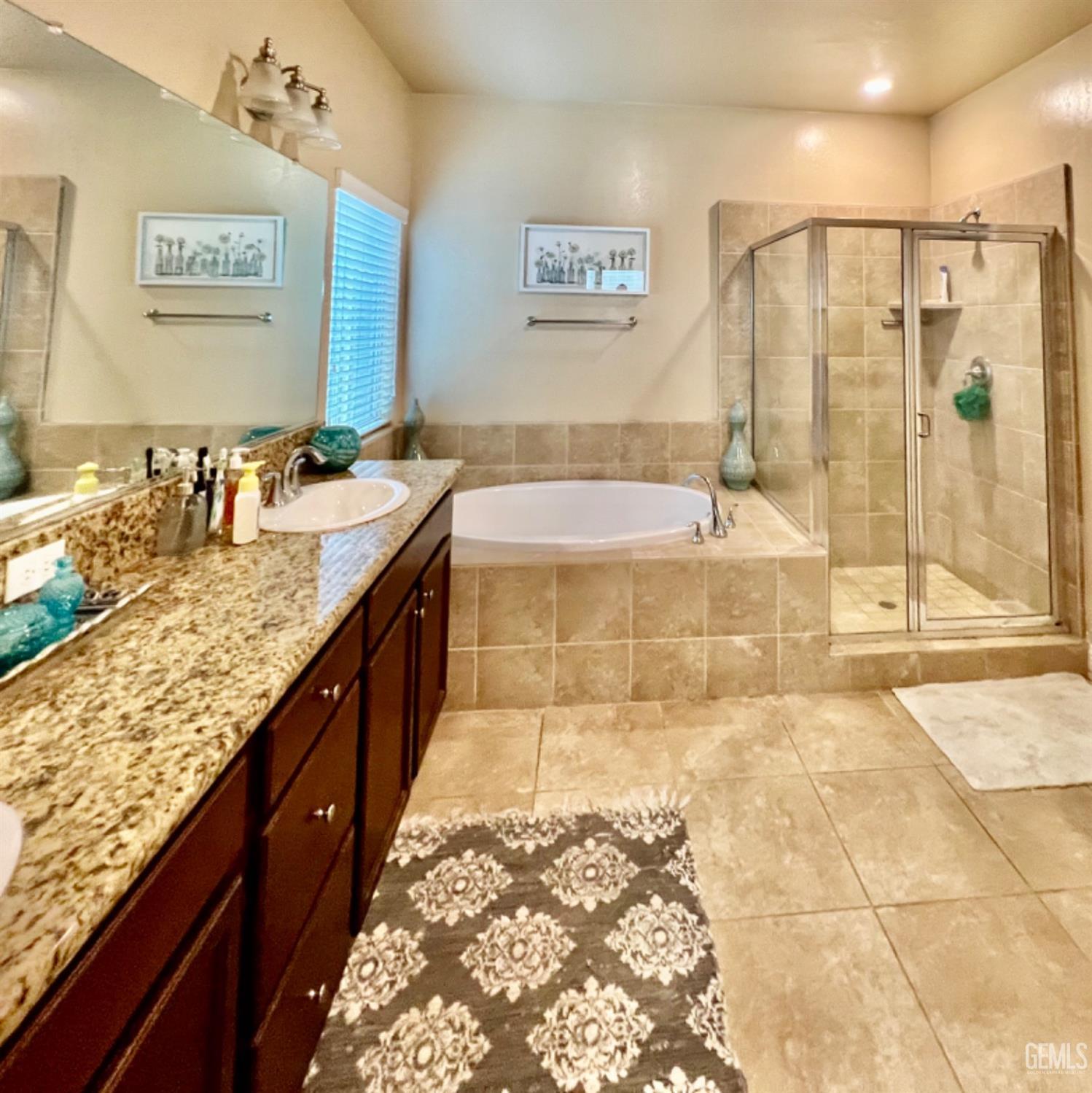 Undisclosed Address Bakersfield, CA 93311 - Photo 48 of 63 a bathroom with a granite countertop sink a mirror a bathtub and shower
