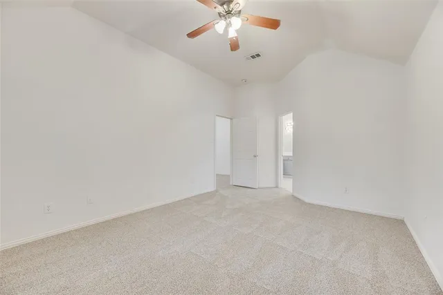 a view of an empty room with a chandelier fan