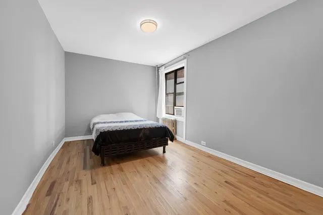 an empty room with wooden floor a ceiling fan and windows