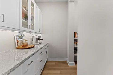 a kitchen with granite countertop a stove a sink a dining table and chairs